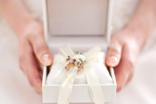 close up female hand holding wedding rings box